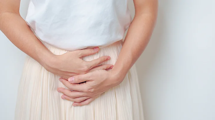 Mulher com a mão na barriga