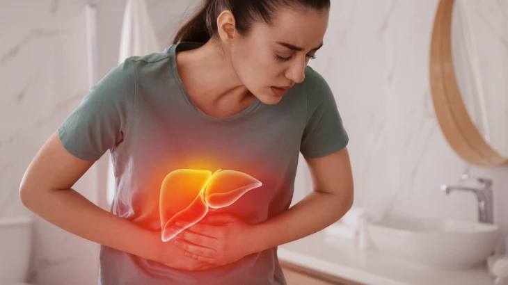 Mulher em pé com a mão na barriga