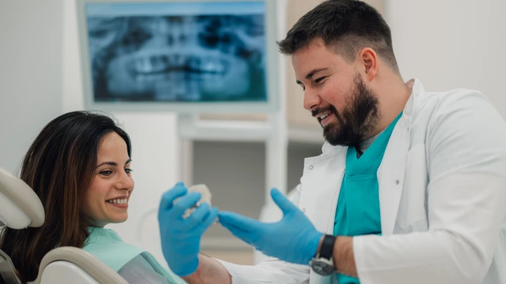 Paciente segurando uma prótese dentária