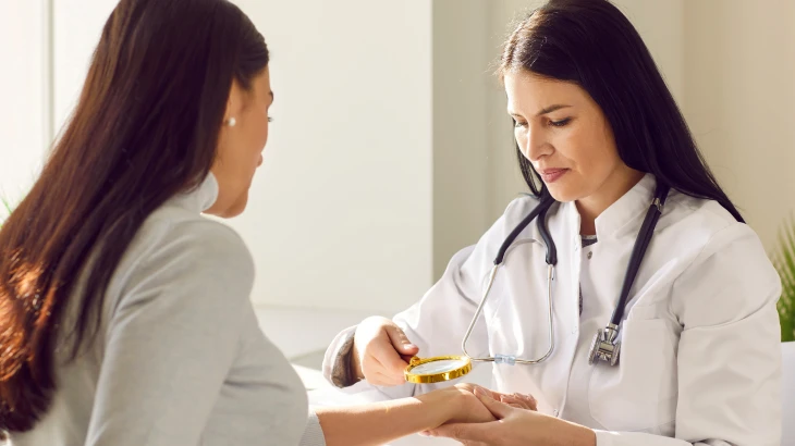 Dermatologista olhando a pele da paciente