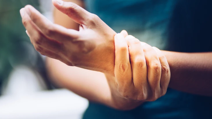 Pessoa apertando o pulso