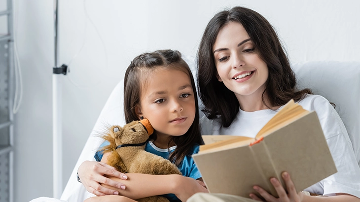 Familia se abraçando feliz no leito de um hospital.