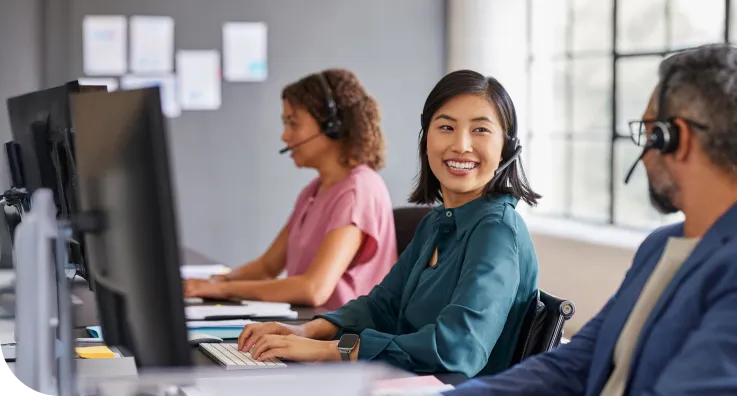 Três atendentes trabalhando no computadr.